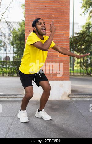 Junger Schwarzer, der Spaß hat, auf der Straße zu tanzen, mit urbanen Tänzen, vertikalem Foto Stockfoto