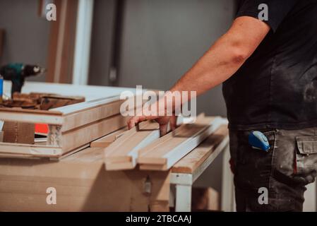 Ein Facharbeiter in der Holzbearbeitungsindustrie nutzt moderne Maschinen, um Holztüren für den Markt zu verarbeiten und vorzubereiten Stockfoto