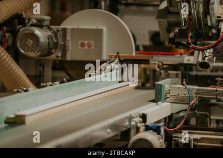 Eine hochmoderne CNC-Maschine in einer modernen Holzverarbeitungsanlage zeigt die nahtlose Verschmelzung von Präzisionstechnologie und traditioneller Technologie Stockfoto