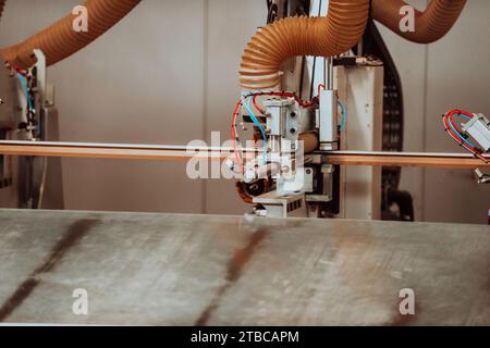 Eine hochmoderne CNC-Maschine in einer modernen Holzverarbeitungsanlage zeigt die nahtlose Verschmelzung von Präzisionstechnologie und traditioneller Technologie Stockfoto