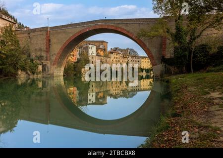 Blick auf Fossombrones charmante Altstadt vom Park aus, mit der Ponte della Concordia, die sich über den Metauro-Fluss erstreckt. Stockfoto