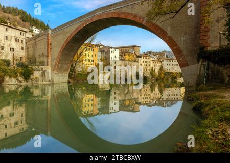 Blick auf Fossombrones charmante Altstadt vom Park aus, mit der Ponte della Concordia, die sich über den Metauro-Fluss erstreckt. Stockfoto