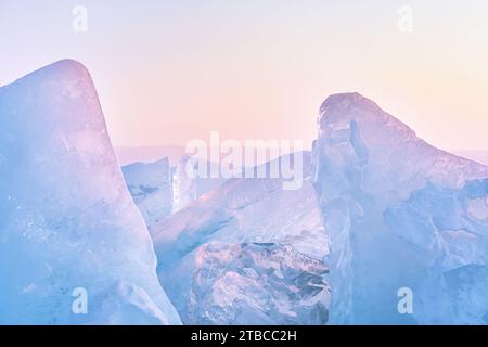 Winterlandschaft mit Eishummocks, die in der Sonne glitzern, und Berge des Baikal-Sees in Sibirien bei Sonnenuntergang. Natürlicher Hintergrund mit Kopierbereich. Stockfoto