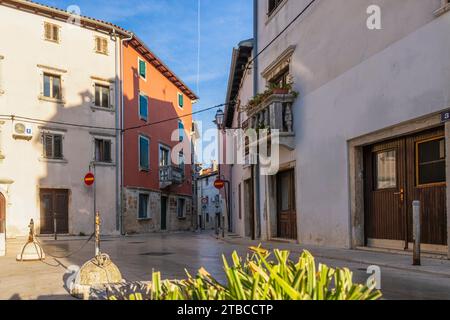 Bild einer typischen Straßenszene aus der historischen kroatischen Stadt Voznjan mit Kopfsteinpflasterstraßen und alten Gebäuden im Morgenlicht Stockfoto