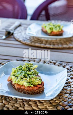 Ein Paar Toastscheiben mit geriebenen Tomaten und zerstoßener Avocado in einem Restaurant. Stockfoto