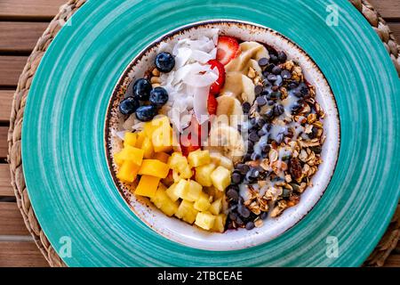 Ein Blick aus der Nähe über eine Schüssel frisch zubereitetes Eis mit geschnittenem Obst und Hafer Stockfoto