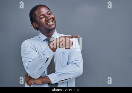 Junger afroamerikaner überrascht, seine Hand zur Seite zu zeigen Stockfoto