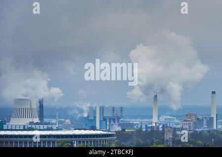 Das Rauchen von Schornsteinen an einem düsteren Tag mit einem Rauchschauer aus einem Kraftwerk oder einer Fabrik zeigt die Umweltkosten für die Stromerzeugung Stockfoto