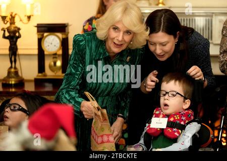 Königin Camilla, begleitet von Kindern, unterstützt von Helen und Douglas House und Roald Dahls wunderbarer Kinderwohltätigkeit, schmückt den Weihnachtsbaum im Clarence House in London. Bilddatum: Mittwoch, 6. Dezember 2023. Stockfoto