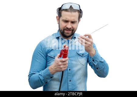 Schweißer, der einen Schweißstab in der Klemme des Elektrodenhalters anordnet. Stockfoto