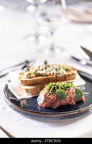 Steak Tartare mit Toast, serviert auf einem Restauranttisch. Stockfoto