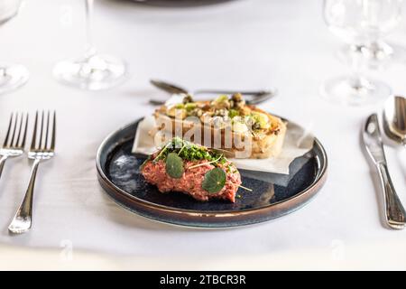 Steak Tartare mit Toast, serviert auf einem Restauranttisch. Stockfoto