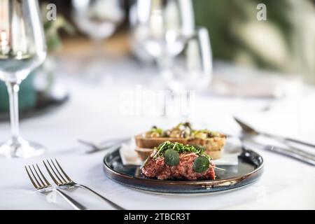 Steak Tartare mit Toast, serviert auf einem Restauranttisch. Stockfoto