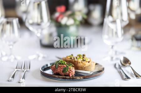 Steak Tartare mit Toast, serviert auf einem Restauranttisch. Stockfoto