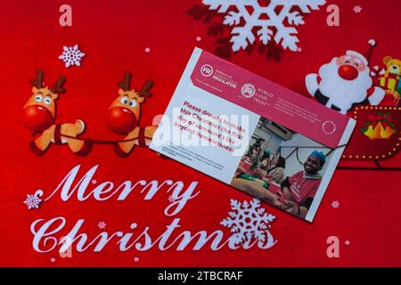 Post auf Weihnachtsmatte - Wohltätigkeitsappell aus Krise Rückseite des Umschlags - Frohe Weihnachten Stockfoto