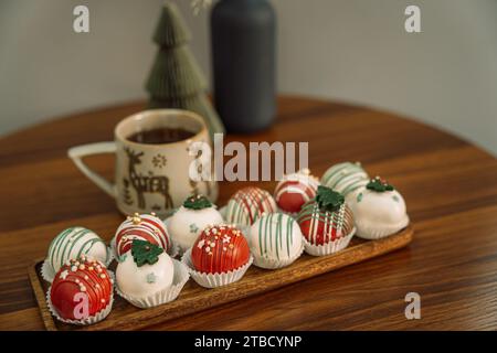 Rum-Kugeln in verschiedenen Farben, dekoriert mit Schokolade in Form von Weihnachtsbaumschmuck Stockfoto