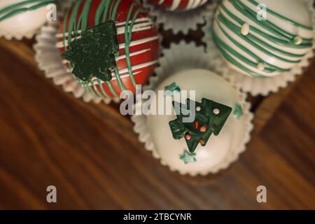 Rum-Kugeln in verschiedenen Farben, dekoriert mit Schokolade in Form von Weihnachtsbaumschmuck Stockfoto