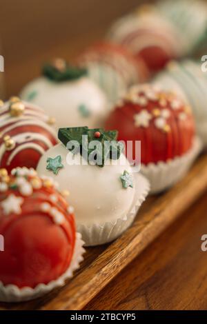 Rum-Kugeln in verschiedenen Farben, dekoriert mit Schokolade in Form von Weihnachtsbaumschmuck Stockfoto