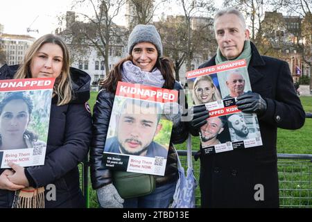 London, Großbritannien. Dezember 2023. Ian Paisley (3. Von links), Parlamentsabgeordneter der Demokratischen Unionistischen Partei (DUP) für North Antrim, hält ein Plakat bei der Mahnwache "Entführt/bringt sie nach Hause" gegenüber den Houses of Parliament in Westminster. Die Mahnwache wird vom Abgeordnetenrat britischer Juden organisiert und soll den Opfern der Hamas-Angriffe in Israel sowie denjenigen, die noch immer von der Hamas als Geiseln gehalten werden, Tribut zollen. Quelle: Imageplotter/Alamy Live News Stockfoto