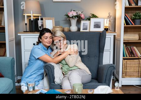 Junge Frau Arzt Gesundheitspersonal medizinische Krankenschwester tröstet ältere ältere Frau zu Hause Besuch, Patient leidet an klinischen Depressionen und Angst. Stockfoto
