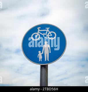 Straßenschilderfahrrad und Fußgängerweg vor blauem bewölktem Himmel Stockfoto