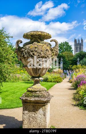 Verzierte Urne aus Stein im Oxford Botanic Garden, mit Magdalen Tower im Hintergrund im Oxford City Centre, Oxfordshire, England, Großbritannien Stockfoto