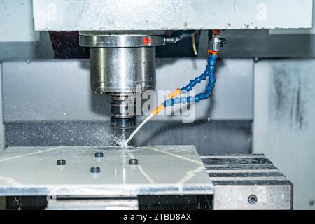 Nahaufnahme einer cnc-Fräsmaschine mit Schneidflüssigkeit zum Schneiden einer Form Stockfoto