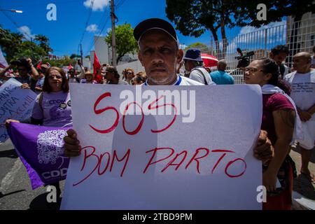 Maceio, Brasilien. Dezember 2023. "S.O.S. Bom Parto", liest das Poster eines Demonstranten in Bezug auf seine Nachbarschaft Bom Parto, die von einer Braskem-Salzmine betroffen ist. Die örtlichen Katastrophenschutzbehörden erklärten den Alarmzustand wegen der Gefahr eines Einsturzes des Salzbergwerks Nr. 18. Vermerk: PEI Fon/dpa/Alamy Live News Stockfoto