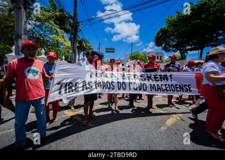 Maceio, Brasilien. Dezember 2023. "Braskem raus", liest das Banner der Demonstranten während eines Protests gegen das Unternehmen und die Schäden, die durch eine Steinsalzmine verursacht wurden. Die örtlichen Katastrophenschutzbehörden erklärten den Alarmzustand wegen der Gefahr eines Einsturzes des Salzbergwerks Nr. 18. Quelle: PEI Fon/dpa/Alamy Live News Stockfoto