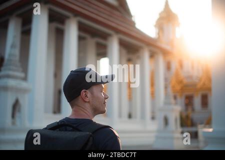 Glücklicher Touristenbesuch im wunderschönen Tempel in Bangkok. Portrat von Alleinreisenden mit Rucksack in Thailand. Stockfoto