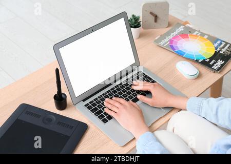 Weibliche Webdesignerin mit Laptop auf dem Tisch Stockfoto