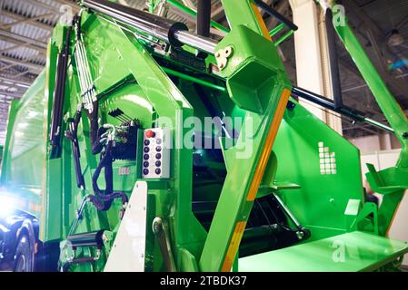 Grüner Müllwagen und Tasten und Hebel der Bedienkonsole Stockfoto