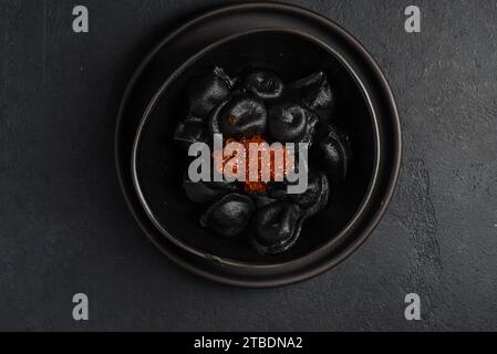 Schwarze Klöße mit rotem Kaviar. Hochwertige Fotos Stockfoto