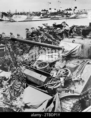 D-DAY britische Soldaten beobachteten von einem Panzerlandefahrzeug kurz vor der Invasion am 6. Juni 1944. Ein Truppenlandeboot ist in der Ferne. Stockfoto