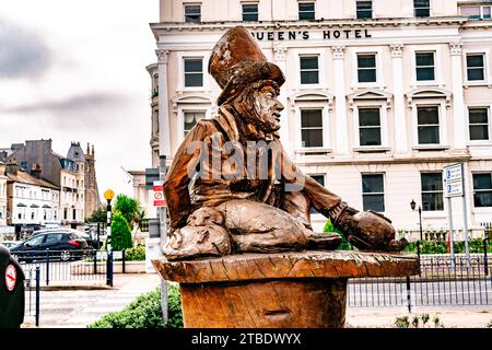 Llandudno, Conwy,. Die Mad Hatter Statue von Alice im Wunderland am Meer mit Chatsworth Hotel im Hintergrund Stockfoto