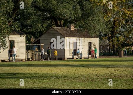 St James Parish, LA, USA - 26. November 2023. Ein Foto von Touristen, die restaurierte Sklavenquartiere aus dem Süden der Vorkriegszeit untersuchen. Stockfoto