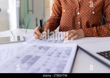 Nahaufnahme der Hände einer Frau, die im Büro am Tisch arbeitet, Geschäftspapiere unterschreibt, mit Dokumenten arbeitet, Papiere bearbeitet. Stockfoto