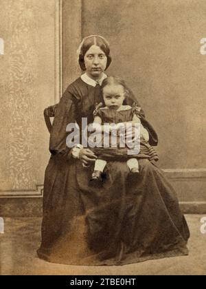 Eine Frau mit einem kleinen Kind auf dem Schoß in einem Liverpool Studio. Stockfoto