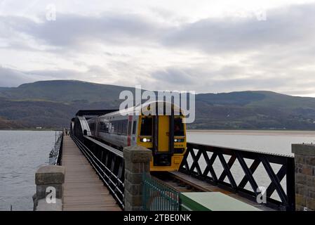 Barmouth, Wales, 6. Dezember 2023. Die berühmte 164 Jahre alte Barmouth Bridge wurde diese Woche nach einer dreimonatigen Schließung für den Wiederaufbau wieder für Züge eröffnet. Das Gebäude wurde von Network Rail und den Bauunternehmen Alun Griffiths komplett umgebaut und ersetzt die Stahlspanen durch genaue Nachbildungen der Originale. Die Brücke liegt an der Cambrian Coast Railway Line, die oft als eine der schönsten Eisenbahnstrecken Großbritanniens gilt. G.P. Essex/Alamy Live News Stockfoto