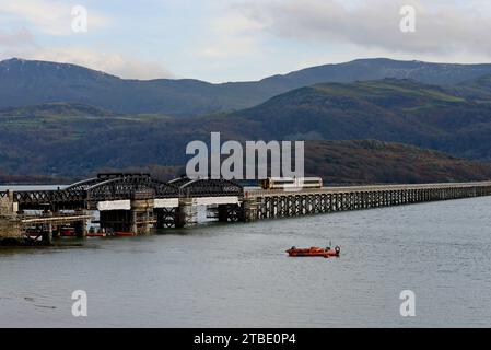 Barmouth, Wales, 6. Dezember 2023. Die berühmte 164 Jahre alte Barmouth Bridge wurde diese Woche nach einer dreimonatigen Schließung für den Wiederaufbau wieder für Züge eröffnet. Das Gebäude wurde von Network Rail und den Bauunternehmen Alun Griffiths komplett umgebaut und ersetzt die Stahlspanen durch genaue Nachbildungen der Originale. Die Brücke liegt an der Cambrian Coast Railway Line, die oft als eine der schönsten Eisenbahnstrecken Großbritanniens gilt. G.P. Essex/Alamy Live News Stockfoto