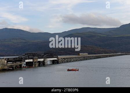 Barmouth, Wales, 6. Dezember 2023. Die berühmte 164 Jahre alte Barmouth Bridge wurde diese Woche nach einer dreimonatigen Schließung für den Wiederaufbau wieder für Züge eröffnet. Das Gebäude wurde von Network Rail und den Bauunternehmen Alun Griffiths komplett umgebaut und ersetzt die Stahlspanen durch genaue Nachbildungen der Originale. Die Brücke liegt an der Cambrian Coast Railway Line, die oft als eine der schönsten Eisenbahnstrecken Großbritanniens gilt. G.P. Essex/Alamy Live News Stockfoto