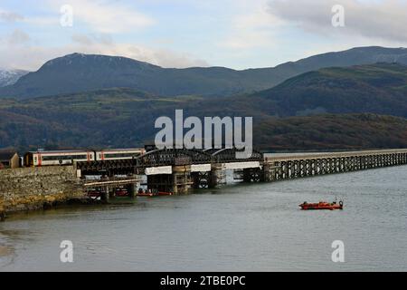 Barmouth, Wales, 6. Dezember 2023. Die berühmte 164 Jahre alte Barmouth Bridge wurde diese Woche nach einer dreimonatigen Schließung für den Wiederaufbau wieder für Züge eröffnet. Das Gebäude wurde von Network Rail und den Bauunternehmen Alun Griffiths komplett umgebaut und ersetzt die Stahlspanen durch genaue Nachbildungen der Originale. Die Brücke liegt an der Cambrian Coast Railway Line, die oft als eine der schönsten Eisenbahnstrecken Großbritanniens gilt. G.P. Essex/Alamy Live News Stockfoto