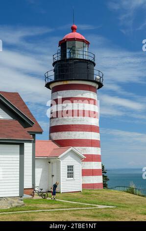 West Quoddy Head Lighthouse. Leuchtfeuer in rot-weißen Streifen mit blauem Himmel auf dem Hintergrund. Stockfoto