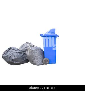 Bild eines blauen Abfallbehälters neben zwei schwarzen Müllsäcken Stockfoto