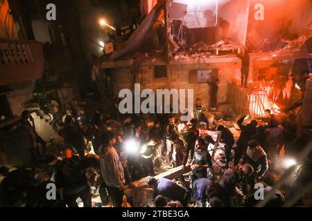 Rafah, Gaza. Dezember 2023. Palästinenser suchen nach Opfern inmitten der Trümmer eines schwelenden Hauses nach einem israelischen Streik in Rafah im südlichen Gazastreifen am Mittwoch, den 6. Dezember 2023. Israel hat seine Offensive gegen die im belagerten südlichen Gazastreifen eingeschlossenen Zivilisten ausgedehnt, so die UNO. Foto: Ismael Mohamad/UPI Credit: UPI/Alamy Live News Stockfoto