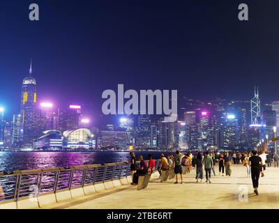 Touristen, die nachts entlang der Hong Kong Avenue of Stars am Ufer von Kowloon spazieren gehen Stockfoto