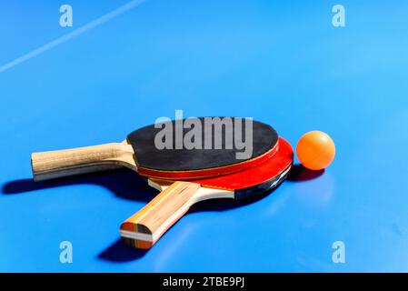 Schläger und Ball auf dem blauen Tennistisch. Nahaufnahme. Stockfoto