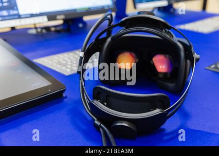 VR-Headset liegt auf dem blauen Schreibtisch, Rückansicht, Nahaufnahme mit selektivem Fokus Stockfoto