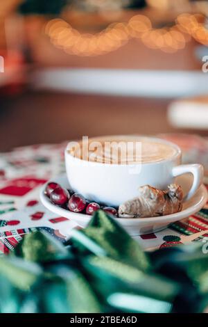 Eine weiße Keramikschale frisch gebrühten Kaffees auf einem Tisch mit festlichen roten und weißen Schleifen Stockfoto