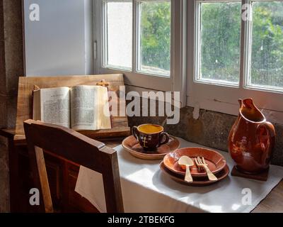 Grande Chartreuse, Frankreich - 30. September 2023: Objekte auf einem Mönchstisch im Kartäuserkloster der Grande Chartreuse: Bibel, Keramikschale, wa Stockfoto